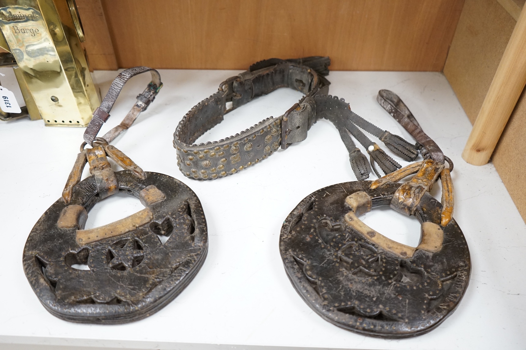 A pair of Argentinian Gaucho leather and piqué work stirrups together with a similar brass mounted belt
